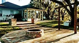 Paver fire pit patio shaded by moss-draped oaks