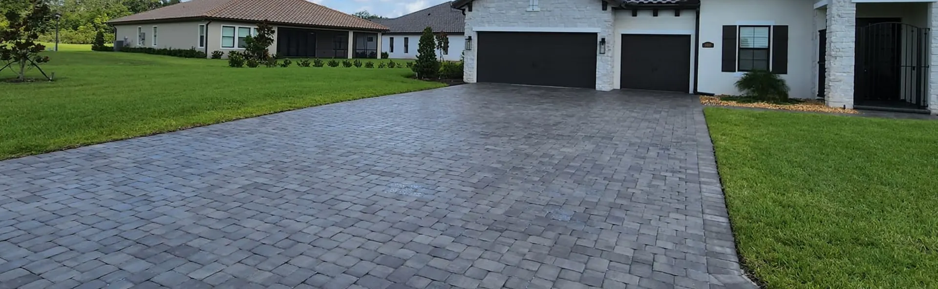 Paver driveway leading to a home