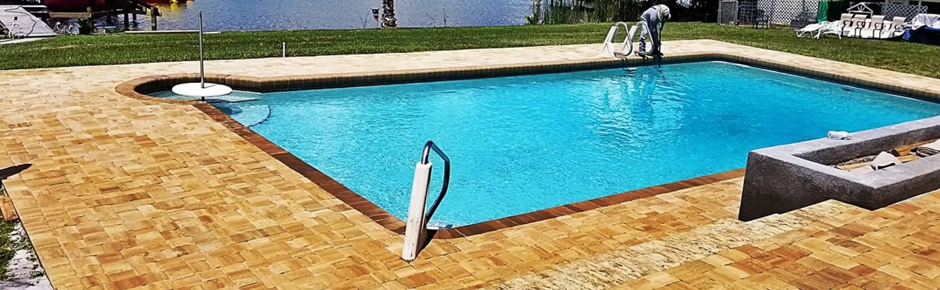 Paver pool deck next to a green lawn